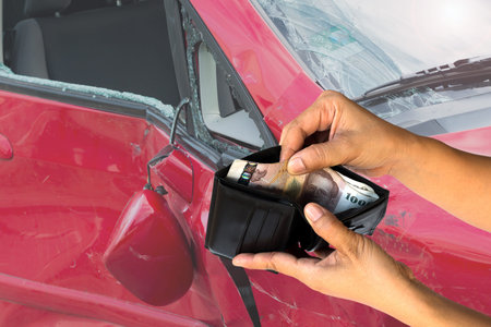 hand hold wallet money over blurred image of broken car