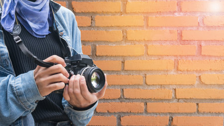 Vintage of women photographer standing and hand holding retro camera on brick wall background