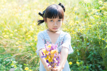 so cute asian little children girl holding flower in her handの写真素材