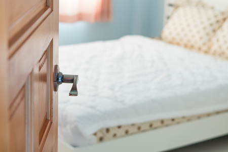 Open door with handle  into a bedroomの写真素材