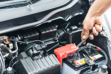Hand of auto mechanic repair car battery in car repair shopの写真素材