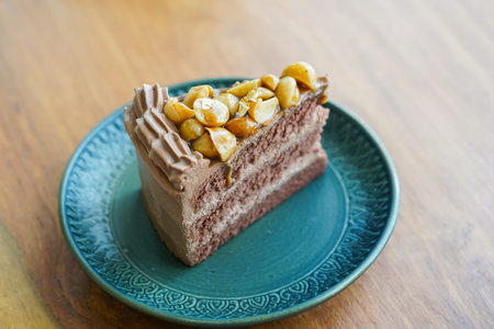 A slice of layered honey chocolate cake with whip cream and almond topping