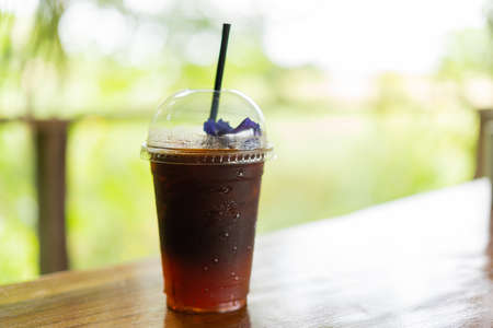 Orange Americano coffee in a take-out cupの写真素材