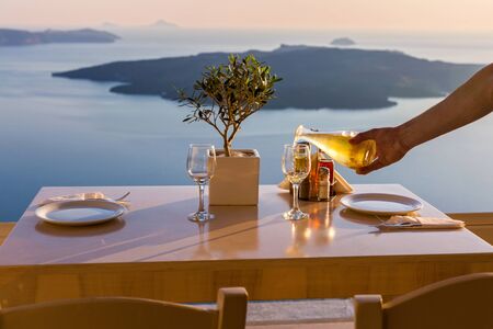Romantic table for two on the island Santorini, Greece. Views of the sea and the volcanoの写真素材