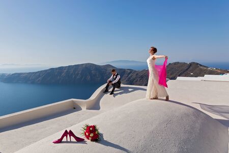 Wedding couple on the roof with views of the sea, Greece, Santoriniの写真素材