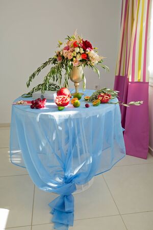 Festive table with fruit and a big bunch of flowersの写真素材