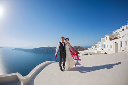 Young couple couple on the roof of the buildings of Santorini, Greeceの写真素材
