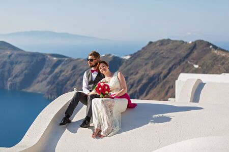 Young couple couple on the roof of the buildings of Santorini, Greeceの写真素材