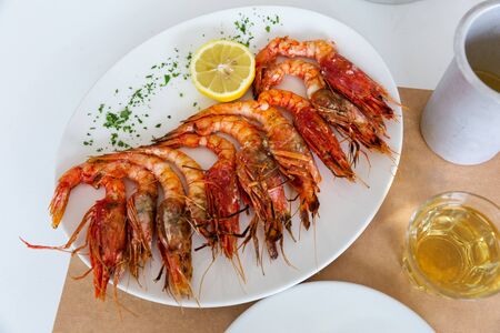 Big plate of fried shrimp and a slice of lemonの写真素材