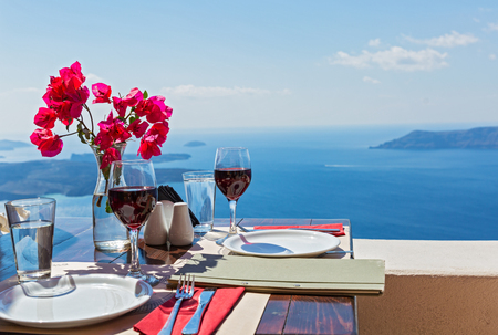 Two glasses of red wine on the table, overlooking the volcano of Santoriniの写真素材