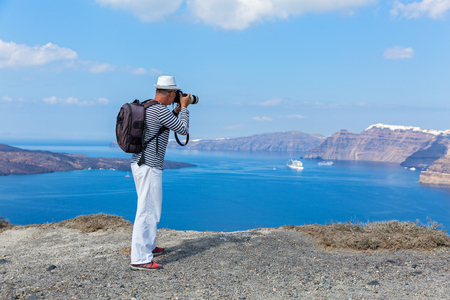 Man photographs the sea and the volcano of Santorini, Greeceの写真素材