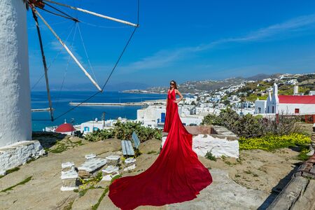 Young woman in red long dress in Mykonos, Greece.の写真素材