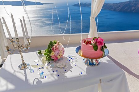 Wedding table with cake and candles on the background of the seaの写真素材
