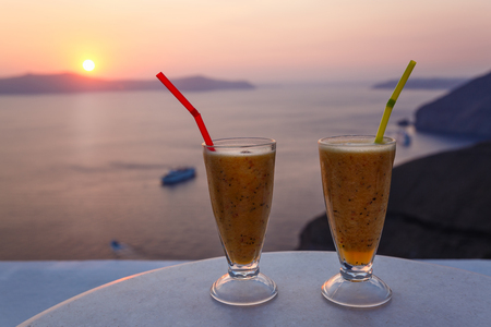 Two glasses with cocktail on the background of sea sunsetの写真素材