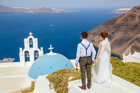 Bride and groom stand next to the sea, Santorini island, Greeceの写真素材