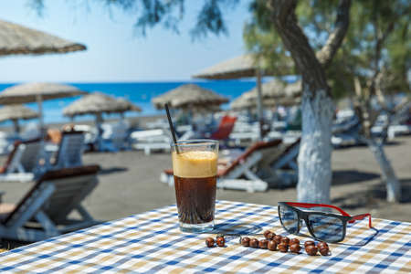 Glass of refreshing cocktail on the table of the cafe against the background of the beachの写真素材