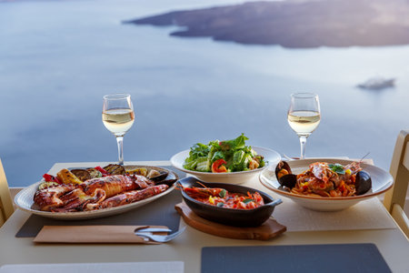 Dinner for two in a restaurant overlooking the sea and the island of Santorini, Greece