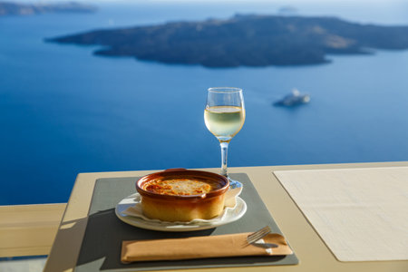 Dinner at a restaurant overlooking the sea and the island of Santorini, Greece