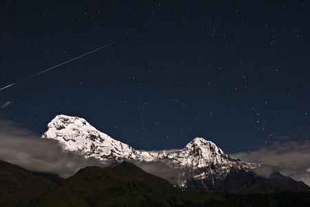 Shooting star over the snow mountainの写真素材