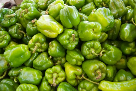 Lots of fresh green peppers for sale on a market の写真素材