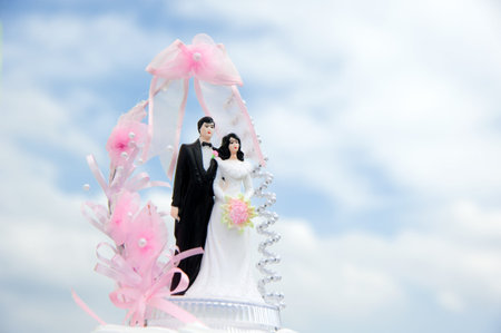 Wedding bride and groom couple doll on cake of an outdoor wedding の写真素材