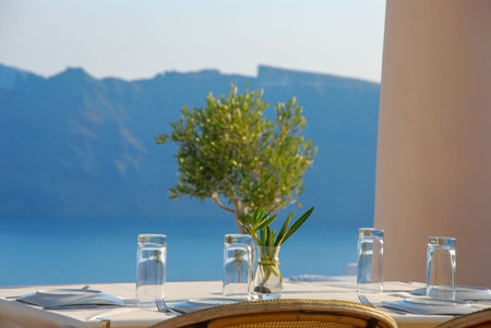 Balcony with a view overlooking caldera of Santorini island, Greece. Olive tree. White wall