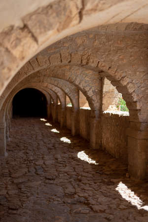 Balcony of an old castle. Arches leading to a dark tunnel end.のeditorial素材