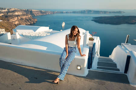 Beautiful girl walking on the street in Imerovigli village in Santorini island Greeceの写真素材