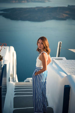 Beautiful girl walking on the street in Imerovigli village in Santorini island Greeceの写真素材