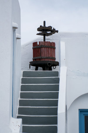 Vintage wine press used as decoration. Decor element on a staircase. Outdoors