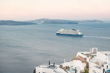 A cruise ship arriving to Santorini island, Greece at sunrise. Greek tourismの写真素材