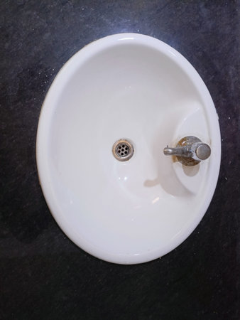 White washbasin with water tap and faucet in bathroom