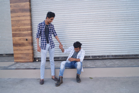 Friends holding hands by closed shutter