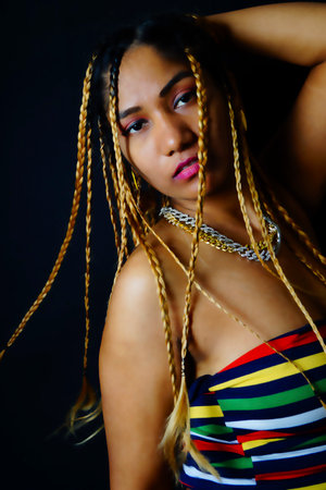 Braided hair woman wearing chain against black background  , Nikita Devの写真素材
