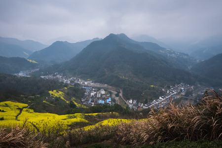 Village on a mountain with rapeseed farmの写真素材