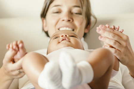 Portrait of a mother with her baby at home. Happy child near to mum in her room.の写真素材