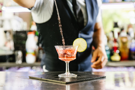 Expert barman is making cocktail at night club.の写真素材