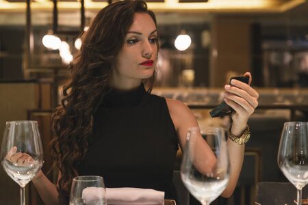 Attractive female use mirror to makeup in luxury restaurantの写真素材