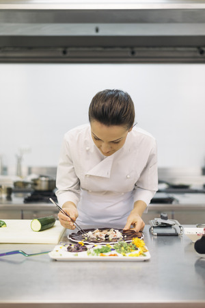 Pretty professional chef cooking in a kitchen.Cooking concept.の写真素材
