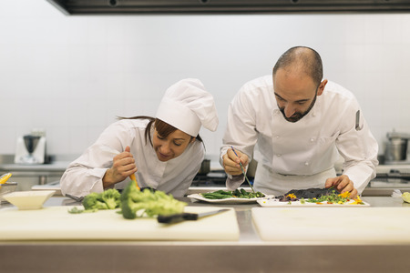 Two professionals chefs cooking together in a kitchen.の写真素材