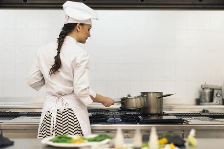 Pretty professional chef cooking in a kitchen.の写真素材