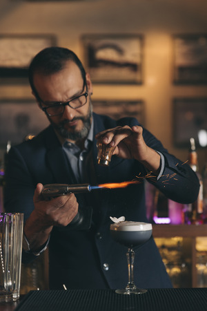 Expert barman is making cocktail at night club.の写真素材