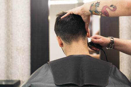 Hairstylist making men's haircut to an attractive man in the beauty salon.の写真素材