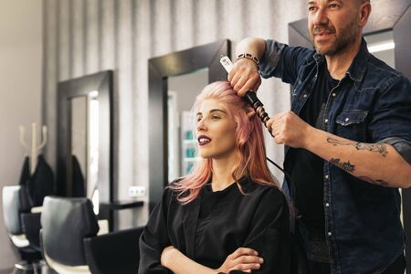 Beautiful woman getting haircut by hairdresser in the beauty salón.の写真素材
