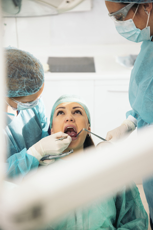 Dentists with a patient during a dental intervention.の写真素材