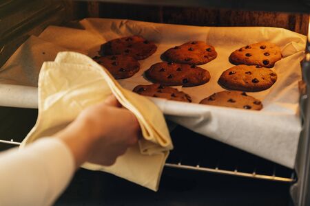 Beautiful woman Preparing Cookies And Muffins at Home.の写真素材