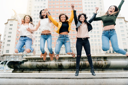 Cheerful Women Jumping Friendship Happiness. Friends Concept
