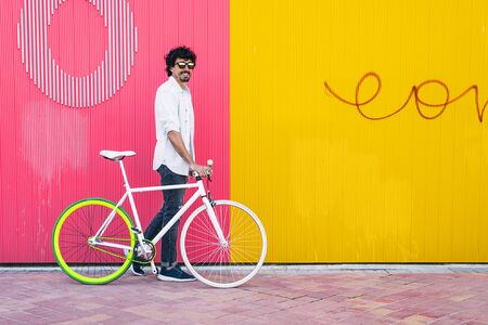 Outdoor portrait of handsome young man with fixed gear bicycle in the street.の写真素材