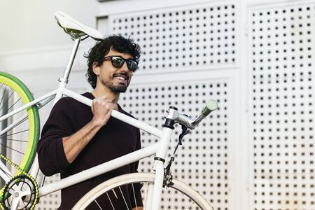 tdoor portrait of handsome young man with fixed gear bicycle in the street.の写真素材