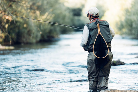 Fly fisherman using flyfishing rod in beautiful river.の写真素材